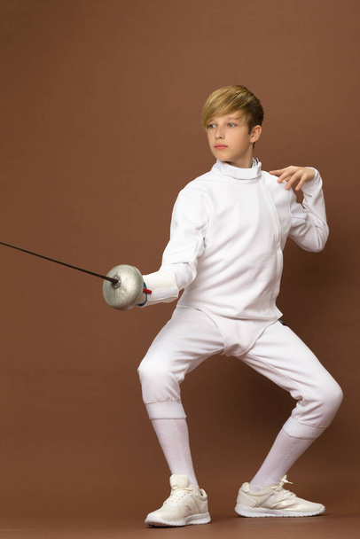 Boy fencer standing in attacking pose - 写真・画像