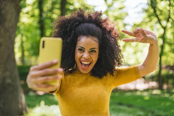 Menina afro bonita tirando uma selfie rindo. - Foto, Imagem