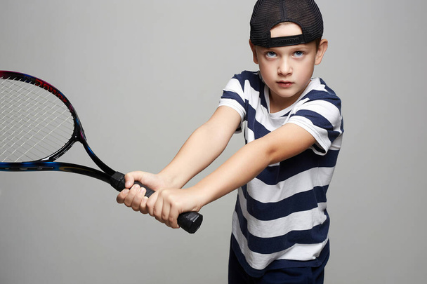 Mały chłopiec gra w tenisa. Dzieciak sportu. Dziecko z rakietą tenisową - Zdjęcie, obraz