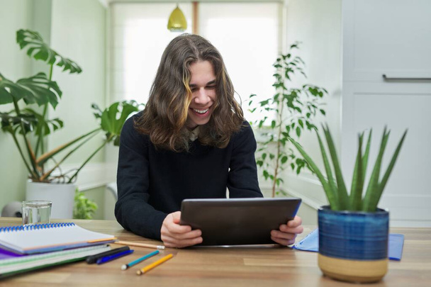 Online lesson, guy student teenager studying at home remotely using digital tablet - Photo, image