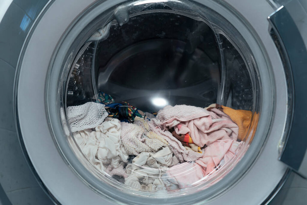 máquina de lavar carga frontal com roupas molhadas e toalha nele - Foto, Imagem