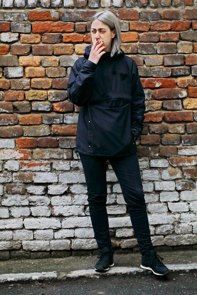 A menina com cabelo prateado vestido de fumaça preta um cigarro - Foto, Imagem