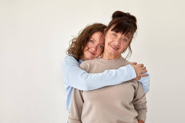 Young woman hugs mature smiling lady in casual clothing - Photo, Image