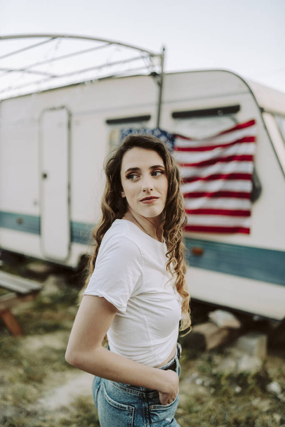 A beautiful Spanish female posing on background of the US flag - US Independence day - 写真・画像