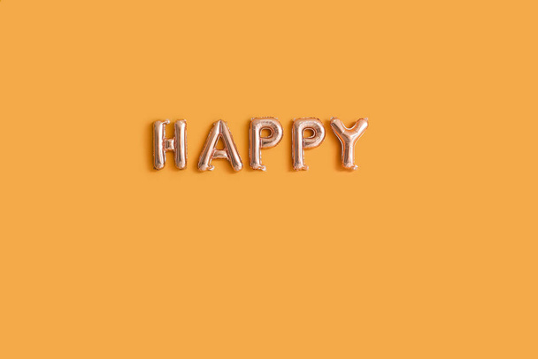 Word HAPPY aus Luftballons auf farbigem Hintergrund - Foto, Bild