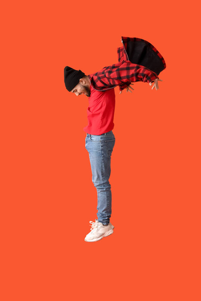 Jumping young man on color background - Фото, зображення