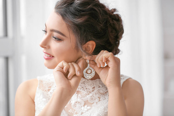 Young bride with beautiful jewelry in room - Photo, Image