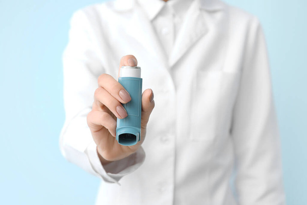 Female allergist with inhaler on color background - Foto, Bild
