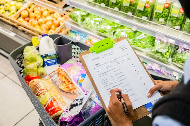 CAPE TOWN, SOUTH AFRICA - Dec 12, 2020: Cape Town, South Africa - December 10, 2020: Staff member picking grocery products from shelf for express home delivery service at local Pick n Pay - Foto, Imagen
