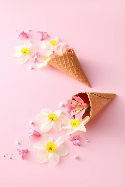 Vafle kornouty s krásnými květinami na barevném pozadí - Fotografie, Obrázek