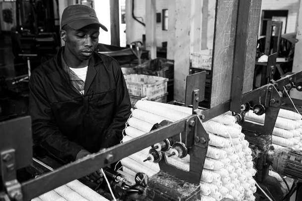JOHANNESBURG, AFRIQUE DU SUD - Jan 06, 2021 : Johannesburg, Afrique du Sud - Le 16 octobre 2012 : Un ouvrier d'usine africain sur un métier à tisser de trame de cuivre - Photo, image