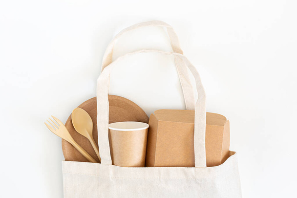 A set of disposable cardboard dishes in a shopping bag on a white background. - Photo, image