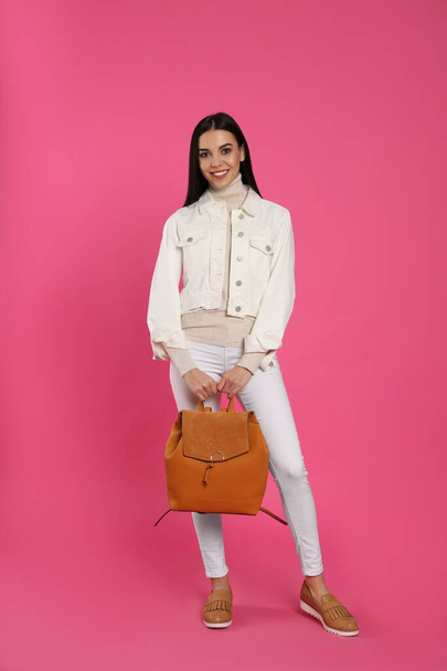 Young woman with stylish backpack on pink background - Photo, image