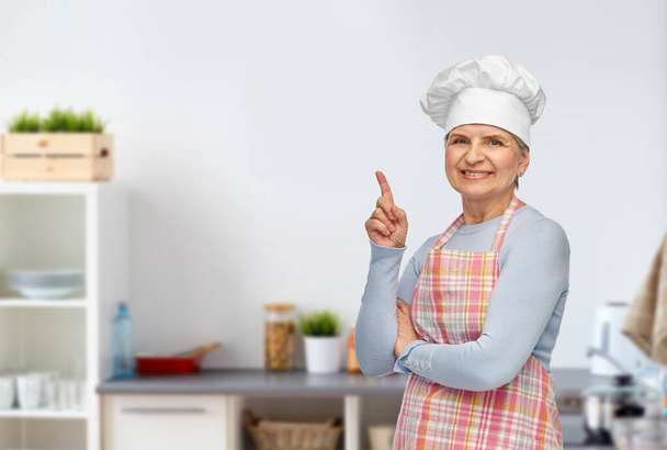 senior woman or chef pointing finger up at kitchen - Zdjęcie, obraz