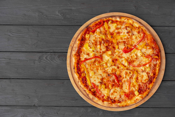 Tasty pizza on black wooden background top view - Φωτογραφία, εικόνα