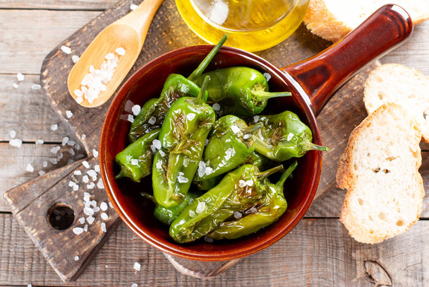 Padron Green pepper випікав або смажив в іспанському стилі в сковороді на дерев'яному столі. Краєвид - Фото, зображення