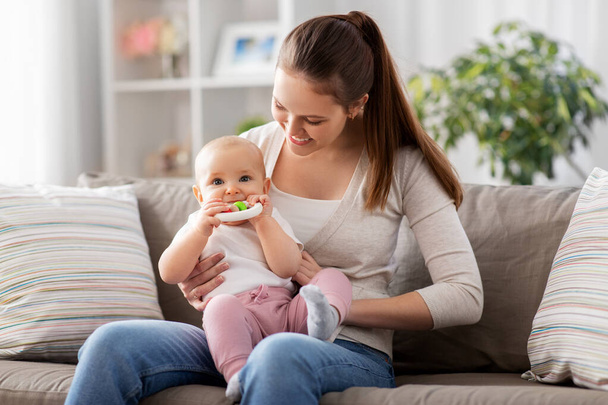 mother and little baby with teething toy at home - Photo, image