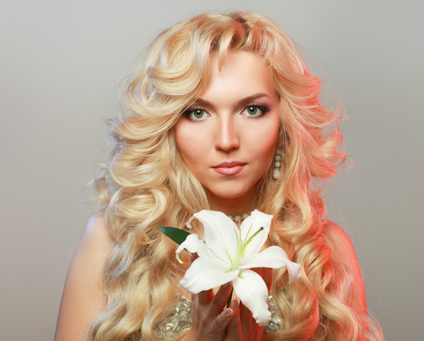 Beautiful woman with flower. Profile portrait of girl on grey background - Zdjęcie, obraz