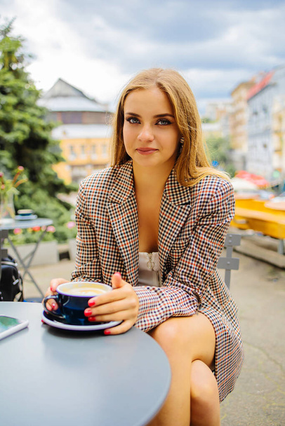 夏のアウトドアカフェでコーヒーを飲む魅力的なビジネス女性 - 写真・画像