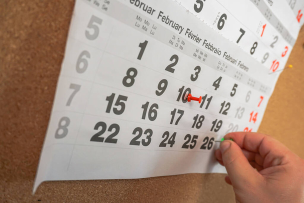 Papel de planificación con calendario pin primer plano a mano de hombre de negocios - Foto, imagen