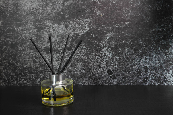 luxe design aroma riet diffuser glazen fles display op de zwarte tafel in de slaapkamer te creat ontspannen ambient - Foto, afbeelding