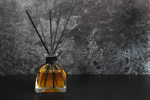 luxe design aroma riet diffuser glazen fles display op de zwarte tafel in de slaapkamer om te ontspannen ambient - Foto, afbeelding