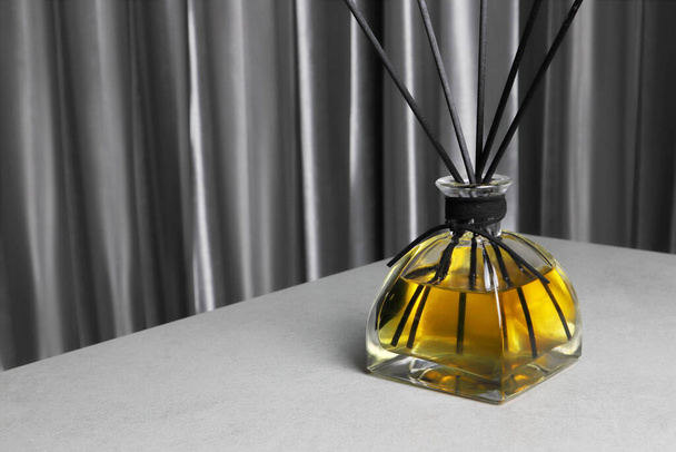 De luxe aromatische geur riet diffuser display op de grijze tafel te creëren van de ontspannen en romantische sfeer in de slaapkamer op Valentijnsdag - Foto, afbeelding