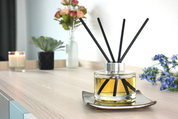 luksusowy aromatyczny zapach butelka szklana dyfuzor trzciny jest używany jako odświeżacz pokój na drewnianym stole w sypialni, aby stworzyć romantyczny i zrelaksować się otoczenia z tłem kwiatów w Walentynki - Zdjęcie, obraz