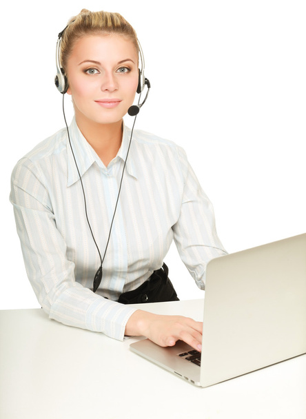 Portrait of beautiful business woman working at her desk with headset and laptop - 写真・画像