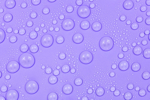 Water drops on purple background texture. Backdrop glass covered with drops of water.  violet bubbles in water - Foto, Imagen