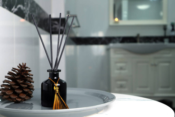 Luxus-Glas Aroma Duft Schilfrohr Diffusorflasche und Duftkerze werden als Lufterfrischer in der schönen weißen Toilette Badezimmer verwendet, um entspannte, gemütliche und saubere Umgebung zu schaffen - Foto, Bild