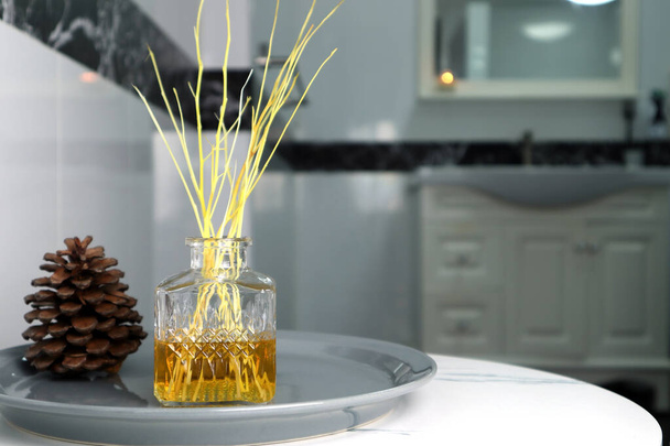 Lüks cam aromalı sazlık kokulu difüzyon çubukları şişesi otel spa merkezindeki rahat, rahat ve temiz ortam yaratmak için güzel beyaz tuvalette oda parfümü olarak kullanılır. - Fotoğraf, Görsel