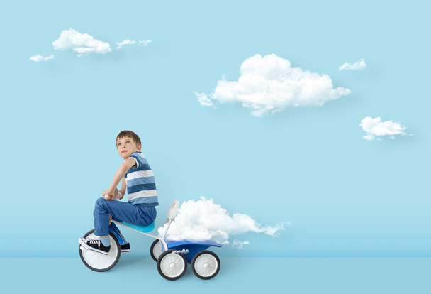 Concept of freedom mind success hope ambition and dream. Clouds creator, surreal concept. Boy carries cloud in the trunk of a bicycle. - Foto, imagen