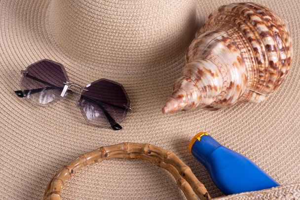 夏の背景。眼鏡、シェル、ビーチバッグ、ビーチストロー帽子. - 写真・画像