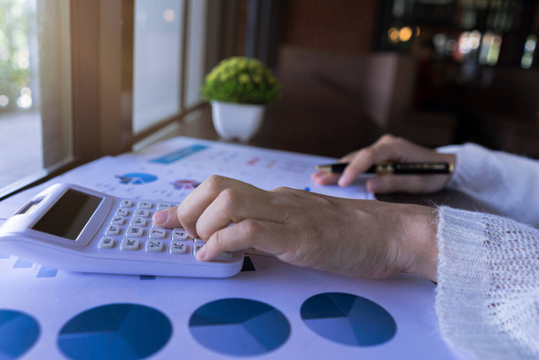 Žena účetní nebo podnikatel pracující s financemi vypočítat na kalkulačka a dokumentovat datový graf v kanceláři místnosti. obchodní účetní koncepce. Zavřít - Fotografie, Obrázek