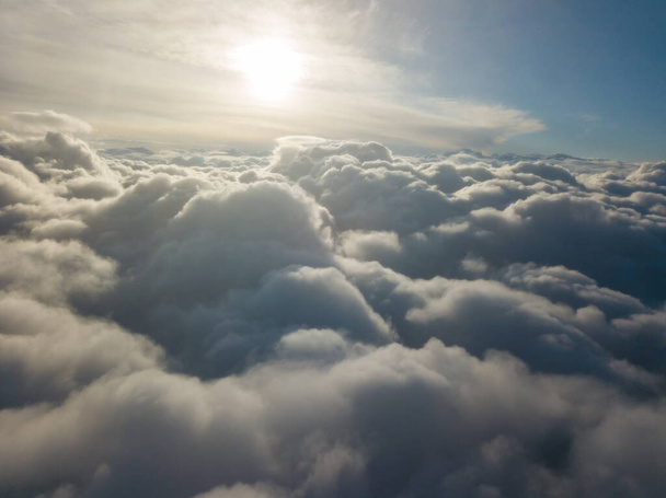 Alto vuelo aéreo sobre las nubes al amanecer. - Foto, imagen