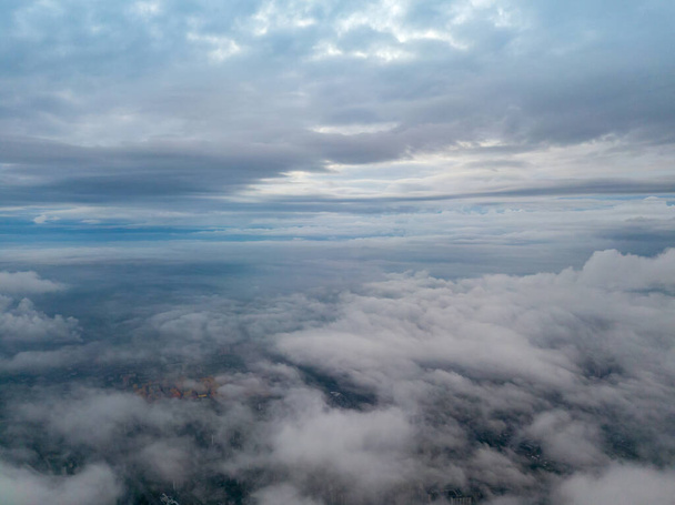 Ciudad bajo las nubes al amanecer. Vista aérea de aviones no tripulados. - Foto, imagen