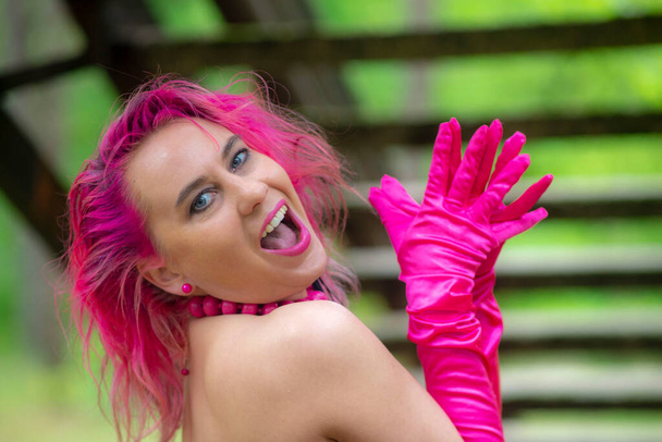 Meisje met roze haar buiten en roze handschoen - Foto, afbeelding