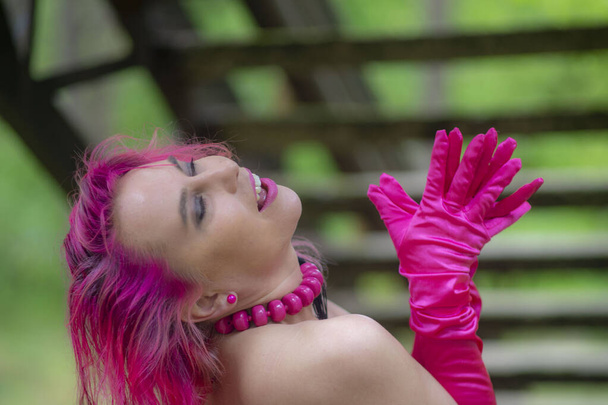 Menina com cabelo rosa ao ar livre e luva rosa - Foto, Imagem
