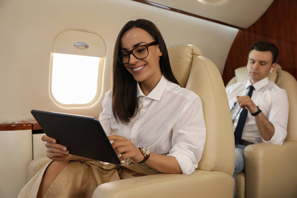 Empresaria trabajando en tablet en avión durante el vuelo - Foto, imagen