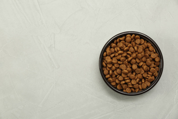 Dry food in pet bowl on grey background, top view. Space for text - Zdjęcie, obraz