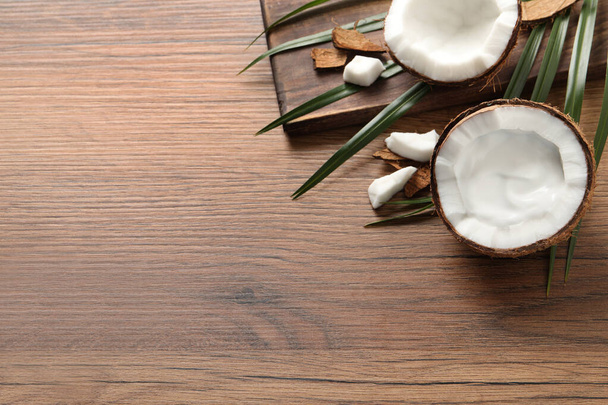 Ripe coconut with cream on wooden table, above view. Space for text - Foto, imagen