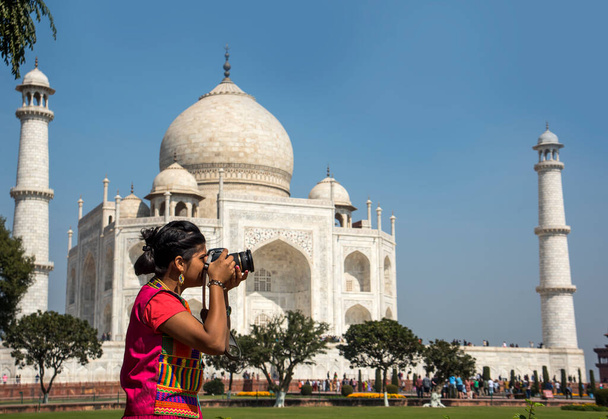 Young girl in traditional clothes is taking photos of Taj Mahal in Agra, India. - Photo, Image
