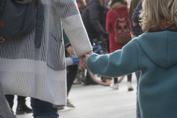 дитина і мати тримаються за руки, ознака довіри і близькості
 - Фото, зображення
