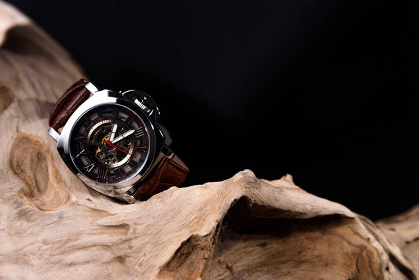 ブラックの背景や隔離された木材の上に置かれた高級男の腕時計の閉鎖 - 写真・画像