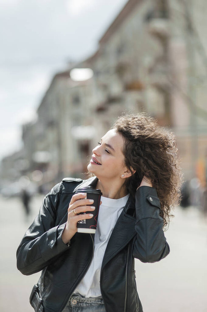 Beautiful girl drinking coffee on the street. - Foto, afbeelding