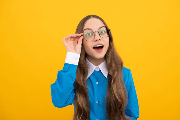Περίεργη σχολική ηλικία κορίτσι παιδί ματιά μέσα από γυαλιά κίτρινο φόντο, περιέργεια. - Φωτογραφία, εικόνα