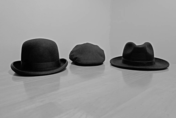 Три старые черные шляпы, лежащие на столе. - Фото, изображение