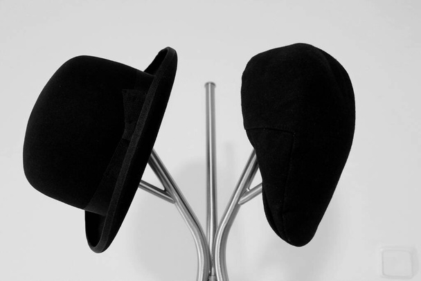 Two old black hats on a stand. - Φωτογραφία, εικόνα