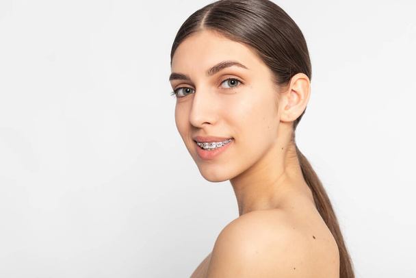 Close up portrait of Smiling Teen girl showing dental braces.Isolated on white background. - Fotografie, Obrázek